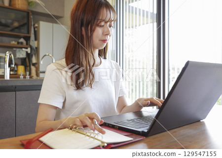 Woman's hand operating a laptop Woman's hand operating a laptop 129547155
