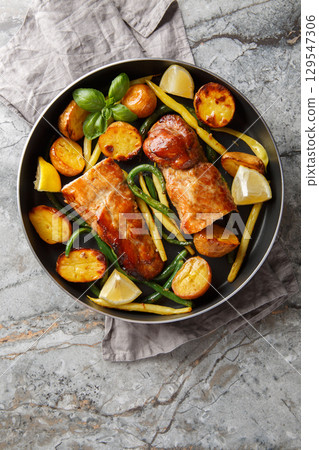 Lemon garlic Pork Tenderloin with french beans and Potatoes close-up in a frying pan. Vertical top view 129547306