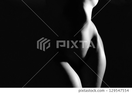 Woman with beautiful naked body studio portrait illuminated with light Woman with beautiful naked body studio portrait illuminated with light 129547554