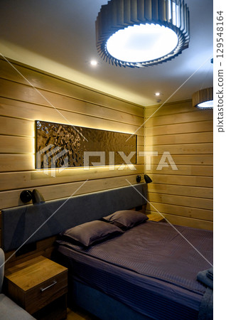 Hotel room with wooden interior, bed and night light Hotel room with wooden interior, bed and night light 129548164