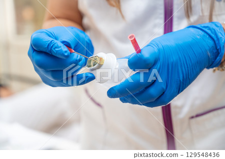 Close up of a nurse preparing an injection 129548436