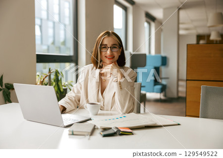 A Confident and Professional Woman Excelling at Work Within a Modern Office Environment 129549522