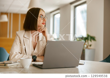 A Professional Woman in a Modern Office Environment Reflecting on Her Work and Future A Professional Woman in a Modern Office Environment Reflecting on Her Work and Future 129549538