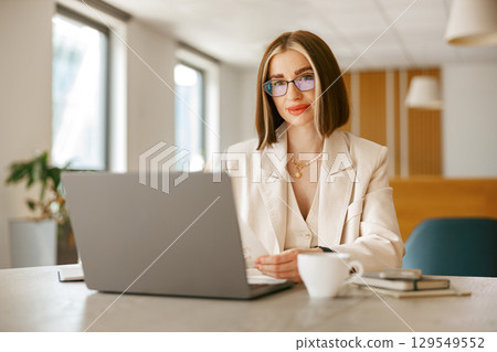 A Young Professional Engaged in Essential Work in a Modern Office Environment Today 129549552