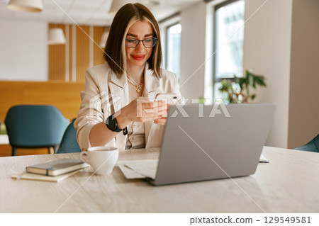 A Professional Woman Diligently Working on Her Laptop in a Modern Office Environment A Professional Woman Diligently Working on Her Laptop in a Modern Office Environment 129549581