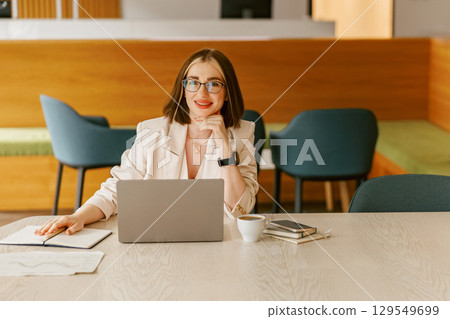 A Professional Woman Engaged in Work Activities Within a Modern, Stylish Office Environment A Professional Woman Engaged in Work Activities Within a Modern, Stylish Office Environment 129549699