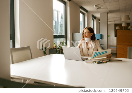 A Business Professional Enjoying a Cup of Coffee in a Modern and Stylish Office Environment A Business Professional Enjoying a Cup of Coffee in a Modern and Stylish Office Environment 129549703