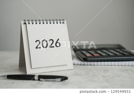 Desk calendar displaying year 2026, alongside calculator and pen. Perfect for showcasing concepts of finance, accounting, planning and business Desk calendar displaying year 2026, alongside calculator and pen. Perfect for showcasing concepts of finance, accounting, planning and business 129549931