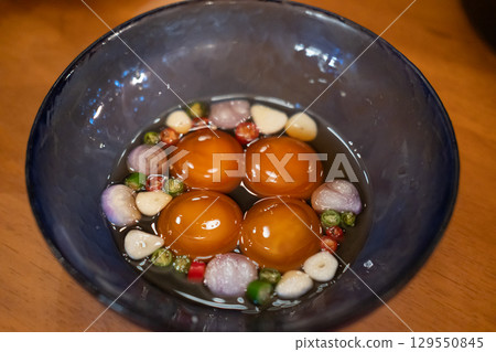 Pickled egg yolk and sauce in a cup 129550845