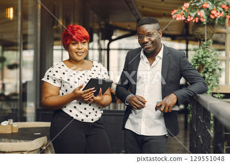 African man. Guy in a black suit. People with a tablet. Girl in white blouse. 129551048