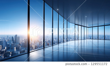 Spacious modern office with large glass windows overlooking a bright sunrise and urban city skyline Spacious modern office with large glass windows overlooking a bright sunrise and urban city skyline 129551172