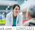 A female doctor smiling and talking to an elderly patient sitting in a wheelchair 129551221