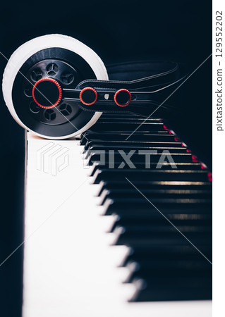 studio headphone on piano keys on black background 129552202