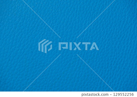 Close-up of vibrant blue faux leather texture, forming an abstract background suitable for upholstery, fashion design, and digital wallpaper concepts 129552256