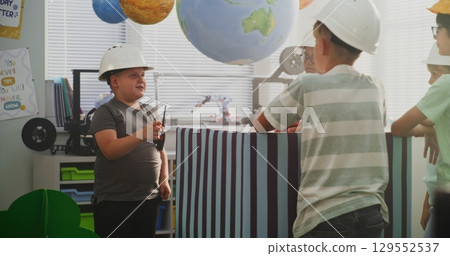 Young Boy Giving Instructions for City Planning. Interactive STEM Class Young Boy Giving Instructions for City Planning. Interactive STEM Class 129552537