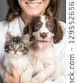 Cute kitten and puppy in the arms of a female veterinarian, in a veterinary clinic. Concept of advertising veterinary services and pet care.  129552656