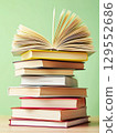 Open book and stack of hardcover books on the table. Concept back to school, education, library. 129552686