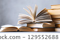 Open book and stack of hardcover books on the table. Concept back to school, education, library. 129552688