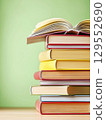 Open book and stack of hardcover books on the table. Concept back to school, education, library. 129552690