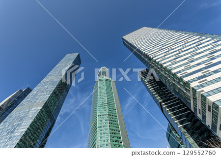 Modern glass skyscrapers on a clear day. Business center of a big city Modern glass skyscrapers on a clear day. Business center of a big city 129552760