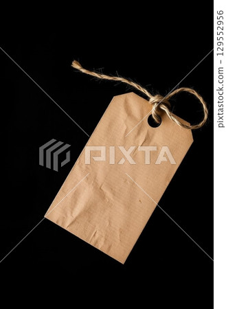 Brown Paper Tag with Twine on Dark Background 129552956