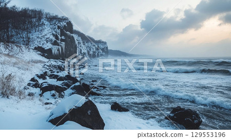 Snowy coastal cliffs and rough seas 129553196