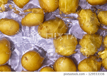 Whole Organic Raw Potatoes In Water Top View, Splash And Ripples. 129553336