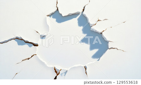 A close-up view of a cracked surface revealing a glimpse of the blue sky behind it, symbolizing breakthrough or revelation 129553618