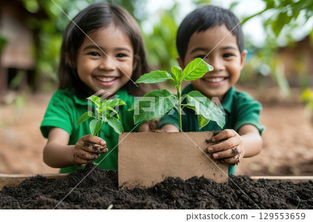 Joyful Children Planting Seedlings in a Garden 129553659