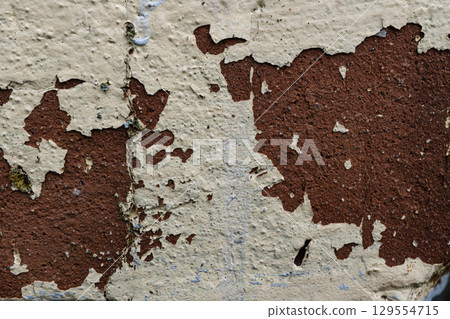 Weathered peeling paint on aged brick wall 129554715