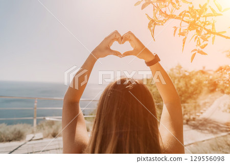 Woman Making a Heart Shape with Her Hands Woman Making a Heart Shape with Her Hands 129556098