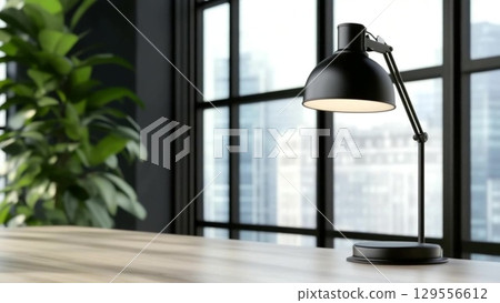 A sleek black desk lamp illuminating a modern workspace with large windows and city view 129556612
