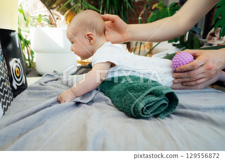 Father massages baby with massage ball. Healthy massage. Massage therapist. Sensory tactile activities. Children health. Massage textured balls for kids. Earlier development. Focus picked 129556872