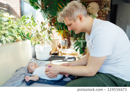 Father massages baby's legs with massage ball. Healthy massage. Massage therapist. Sensory tactile activities. Children health. Massage textured balls for kids. Earlier development. Focus picked. 129556873
