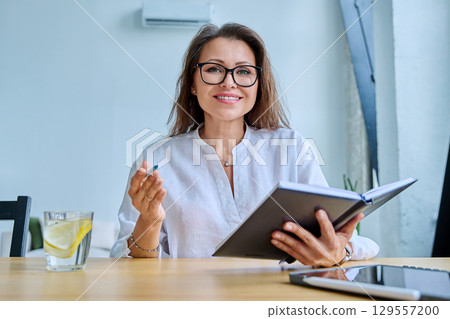 Webcam view woman entrepreneur, teacher, blogger working remotely in home office 129557200