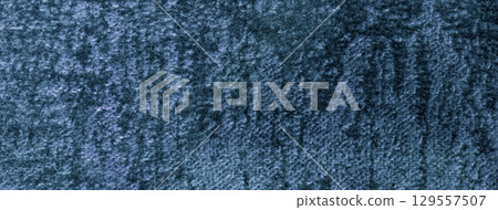 Navy blue fluffy background of soft shiny velour fabric, macro. Texture of dark denim velvet textile backdrop 129557507