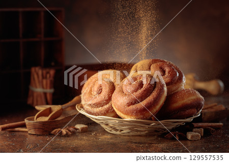 Swedish cinnamon buns are sprinkled with cinnamon powder. 129557535