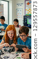 Children engaged in stem learning with robotics in classroom setting 129557873
