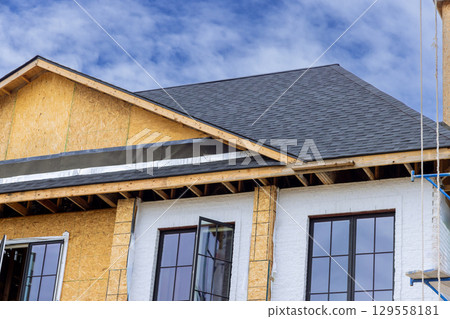 New home construction in progress featuring roof installation wooden framework as clouds drift by New home construction in progress featuring roof installation wooden framework as clouds drift by 129558181