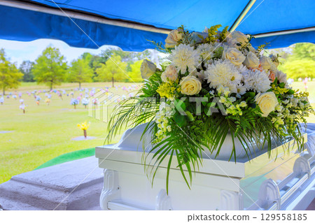 Family and friends gather in serene cemetery during heartfelt farewell ceremony under clear blue sky Family and friends gather in serene cemetery during heartfelt farewell ceremony under clear blue sky 129558185