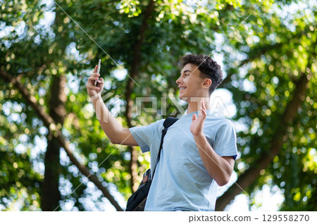 Sweet dark-haired teen with a phone in hands in the park 129558270