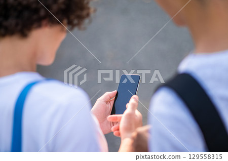 Close up of two teens looking at the phone Close up of two teens looking at the phone 129558315