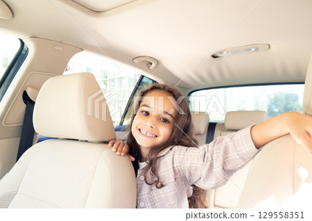 Waist up of a smiling cute girl in the car 129558351