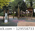 Kids playground in city park with slide, climbing nets, rope bridges and trees around. Fun recreational area for children play, adventure and physical activity outdoors 129558733