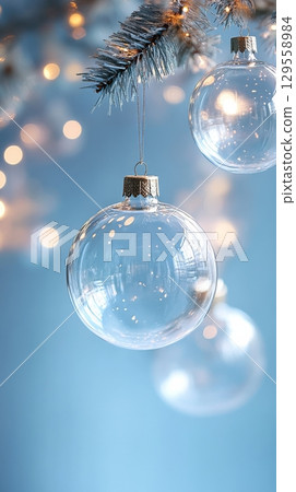 Clear Glass Ornaments Hang on a Winter Tree With Soft Bokeh Lights in the Background 129558984