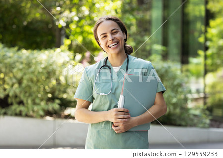Happy smiling young female doctor in a lab coat Happy smiling young female doctor in a lab coat 129559233
