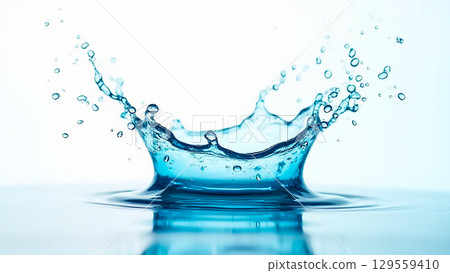 Water splash creating ripples in a calm pool under bright lighting with droplets suspended in air 129559410