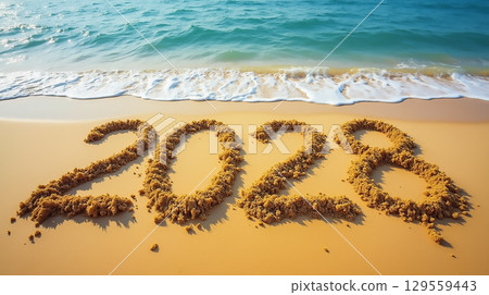Sand inscription of 2028 on a beach shore with gentle waves lapping at the sandy surface Sand inscription of 2028 on a beach shore with gentle waves lapping at the sandy surface 129559443