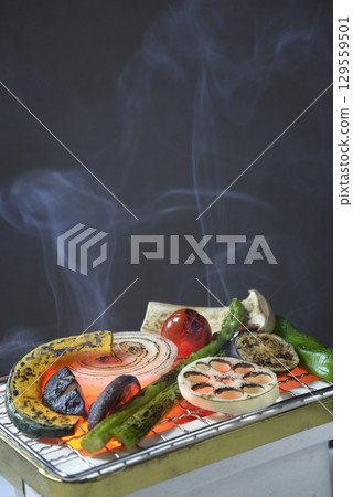 Grilling vegetables on a smoky charcoal grill 129559501