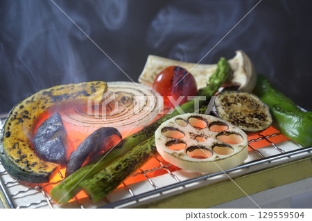 Grilling vegetables on a smoky charcoal grill Grilling vegetables on a smoky charcoal grill 129559504